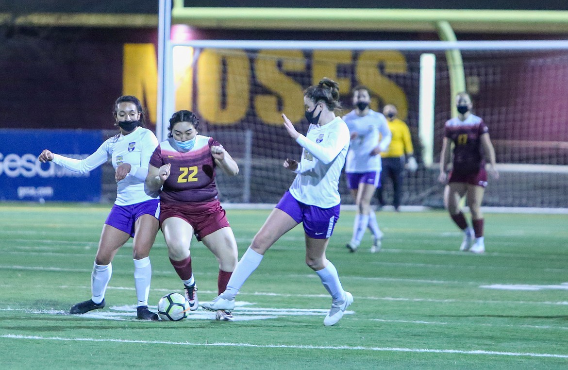Moses Lake midfielder Clarissa Negrete fights off a pair of Wenatchee attackers to steal the ball away shortly after coming off the bench in the first half of the Chiefs' 3-1 defeat on Tuesday night at Lions Field in Moses Lake