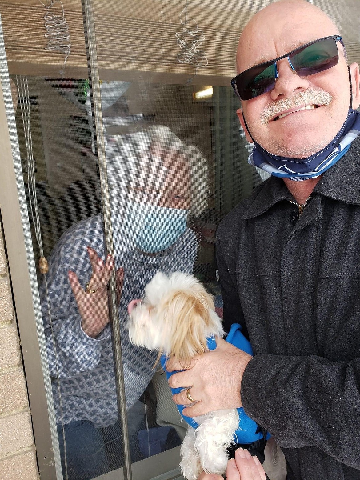 Steve Hanson of Coeur d'Alene and his dog, "Handsome Herbie Hanson," visit with his mom Dorla Johnson on Feb. 20 through the window at Mountain Valley of Cascadia in Kellogg.