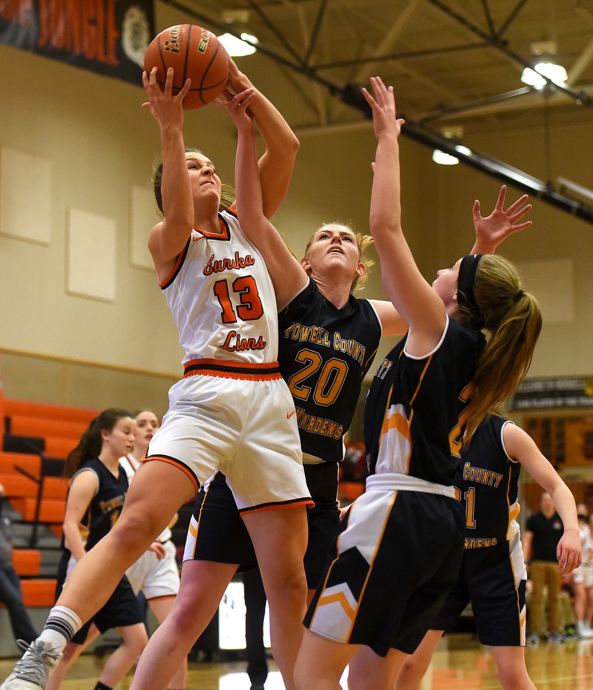 Eureka's Reena Truman goes up for a shot against Deer Lodge defender Emma Johnson at the Western B Divisional Basketball Tournament in Eureka Wednesday. (Jeremy Weber/Daily Inter Lake)