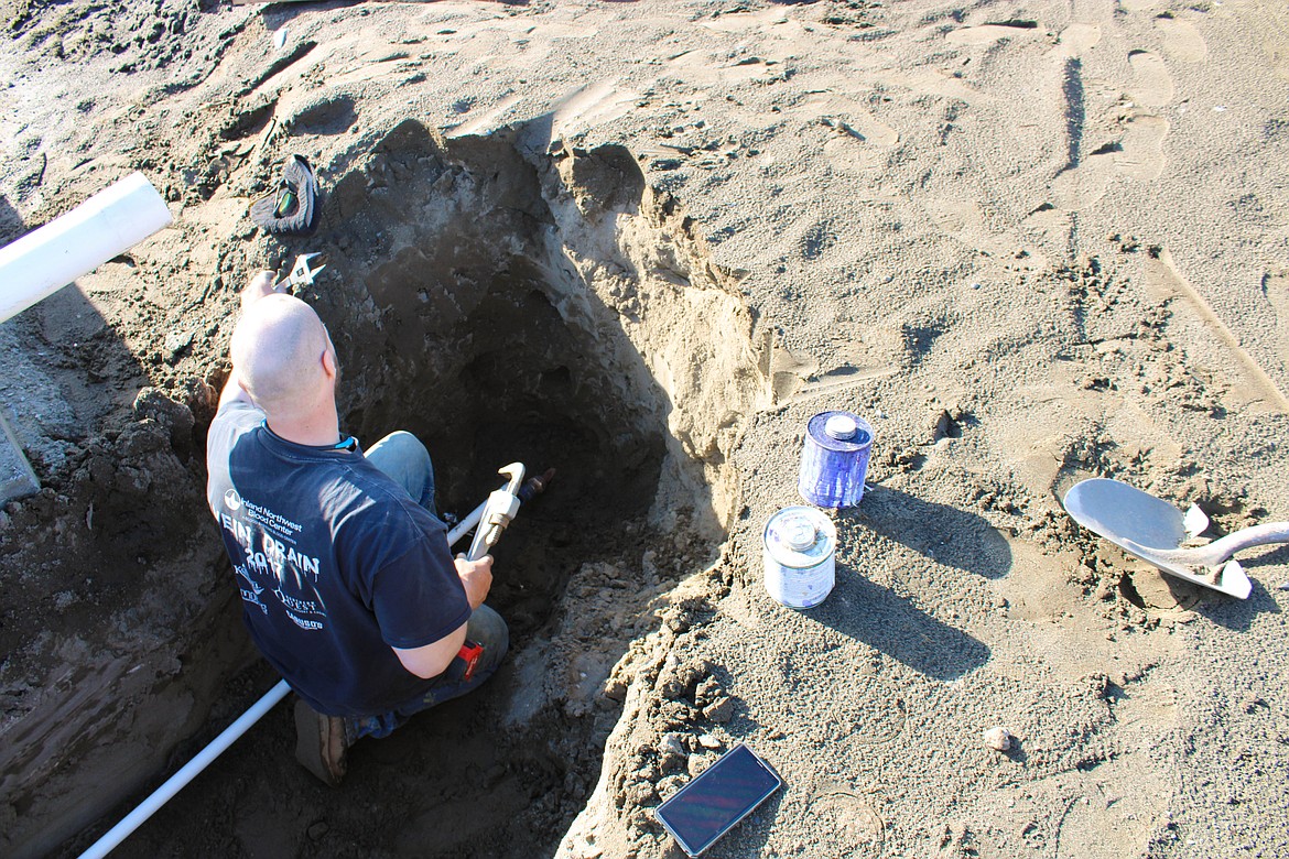 Roger Skjelstad of Pour Boys Concrete installs the new water line near North Hooper Drive in Moses Lake.