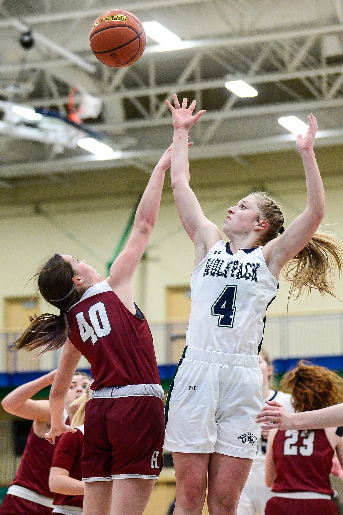 Glacier's Kaylee Fritz (4) goes to the basket against Helena's Maloree English (40) in a state AA play-in game at Glacier High School on Thursday. (Casey Kreider/Daily Inter Lake)