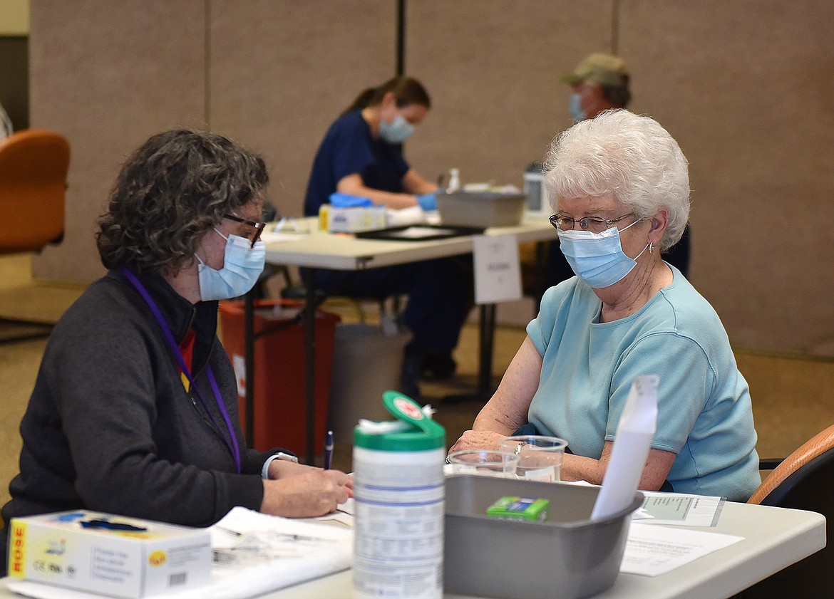 Janice Knapton, right, talks with Heather Murray, North Valley Hospital employee health nurse, prior to receiving the COVID-19 vaccine Thursday at Grouse Mountain Lodge. The hospital is holding weekly vaccine clinics in collaboration with the Flathead City-County Health Department. (Heidi Desch/Whitefish Pilot)