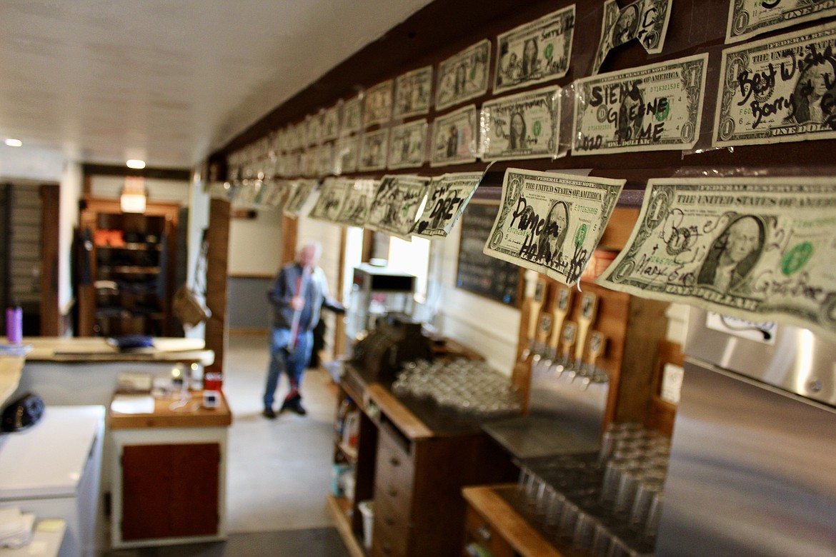 Dozens of dollar bills hang above the main bar at Koocanusa Brewing Company in Eureka. The bills were stapled to the wall by customers who have visited the brewery from near and far. (Kianna Gardner/Daily Inter Lake)