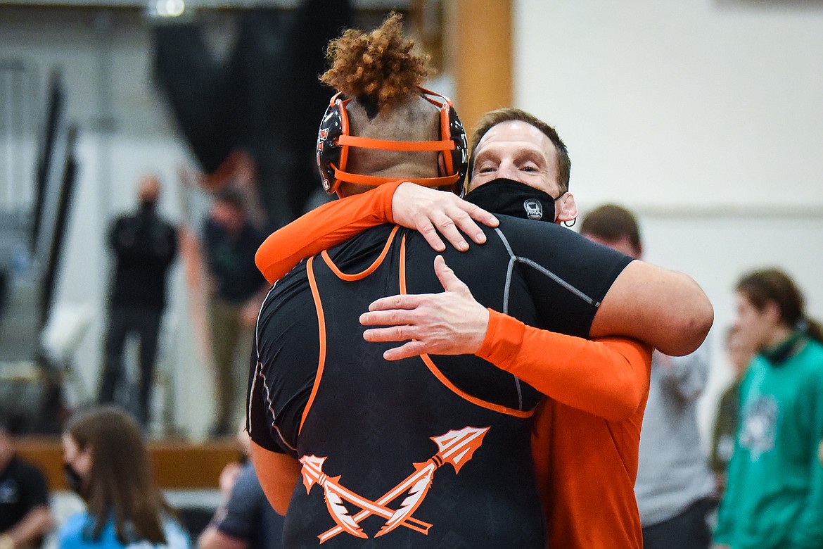 Flathead head coach Jeff Thompson hugs heavyweight Timber Richberg after his win over Great Falls CMR's Idellio Michellotti at the State AA wrestling championships at Flathead High School on Friday. (Casey Kreider/Daily Inter Lake)