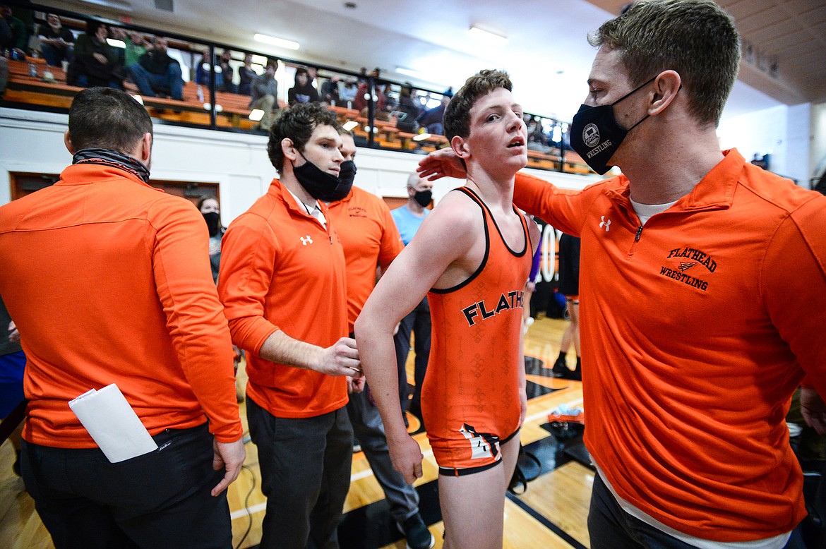 Flathead's Logan Stansberry gets congratulated by Braves assistant coach Justin Whitman after Stansberry's win against Butte's Kyler Raiha at 120 lbs. during the State AA wrestling championships at Flathead High School on Friday. (Casey Kreider/Daily Inter Lake)