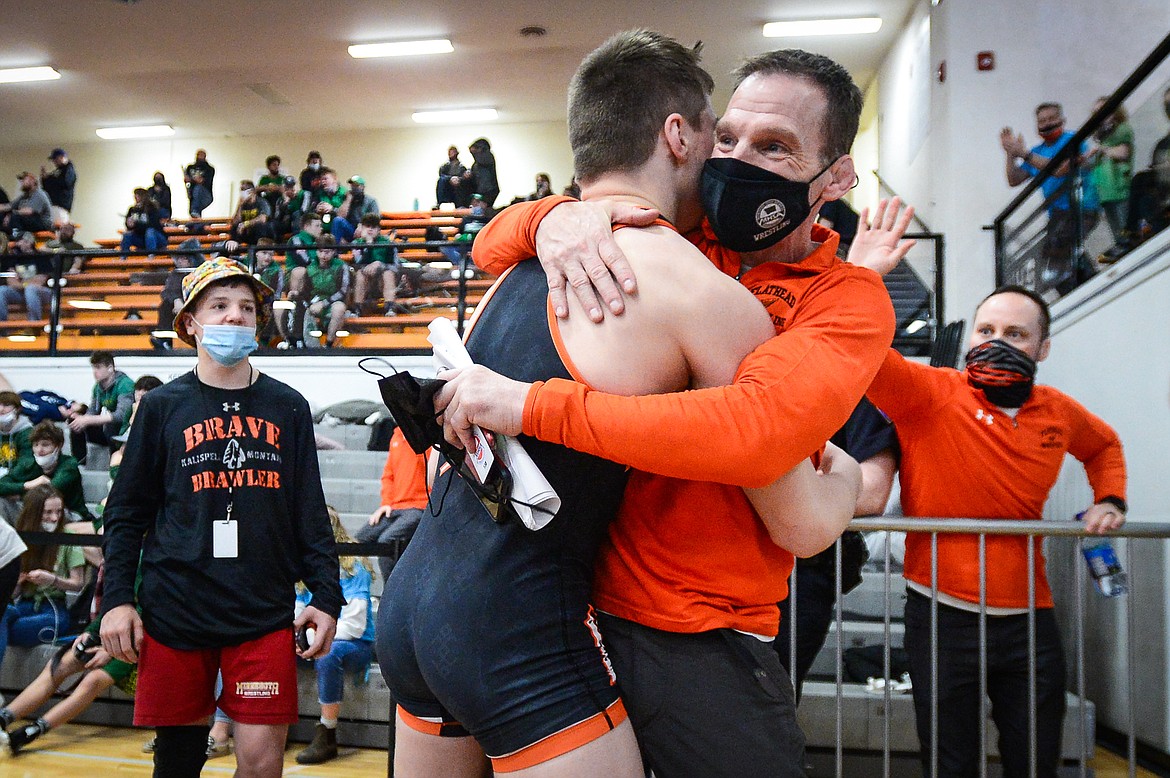 Flathead head coach Jeff Thompson hugs Anders Thompson after his win over Butte's Connor Konda at 138 lbs. at the State AA wrestling championships at Flathead High School on Friday. (Casey Kreider/Daily Inter Lake)