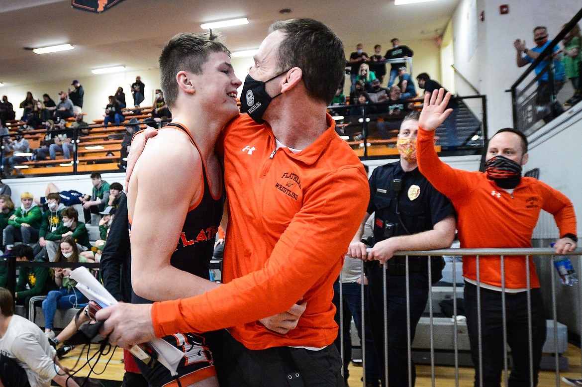 Flathead head coach Jeff Thompson hugs Anders Thompson after his win over Butte's Connor Konda at 138 lbs. at the State AA wrestling championships at Flathead High School on Friday. (Casey Kreider/Daily Inter Lake)