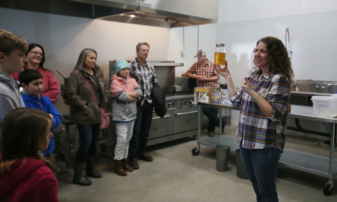 Nikki Conley, who owns Athol Orchards with husband Eric, holds up one of the first jars of Athol Orchards' North Idaho-made maple syrup during a presentation about harvesting and making maple syrup on Thursday.