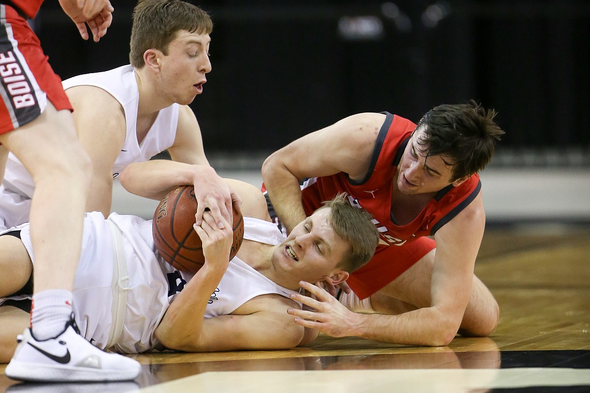 JASON DUCHOW PHOTOGRAPHY
Chris Irvin of Lake City cradles the ball on the floor as Jack Goode of Boise reaches in and Lake City's Ben Janke looks on during Friday's state 5A semifinal at the Ford Idaho Center in Nampa.