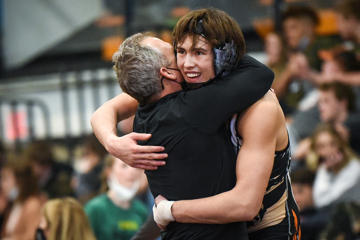 Flathead's Chase Youso gets a hug from a Braves assistant coach after placing third at 170 lbs. at the State AA wrestling tournament at Flathead High School on Saturday. (Casey Kreider/Daily Inter Lake)