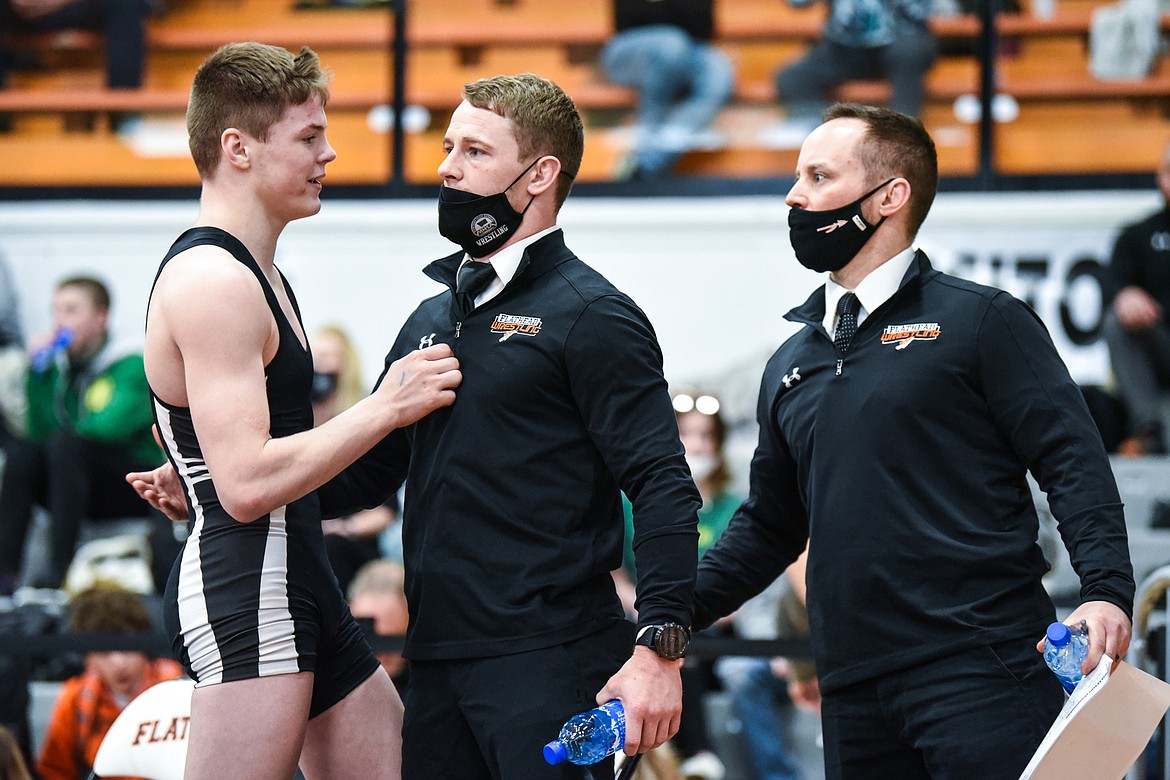 Flathead's Anders Thompson speaks with Braves assistant coaches Justin Whitman and Dallas Stuker after placing fourth at the State AA wrestling tournament at Flathead High School on Saturday. (Casey Kreider/Daily Inter Lake)