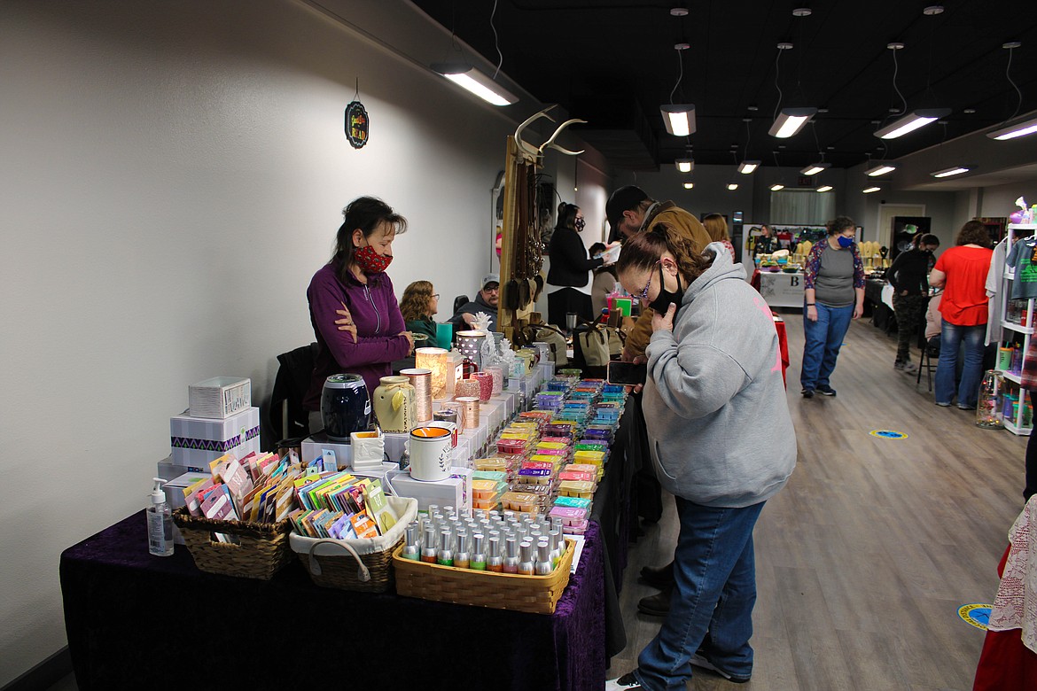 Lori Valdez of Scentsy discusses wickless candles at the Cabin Fever Bazaar on Saturday.