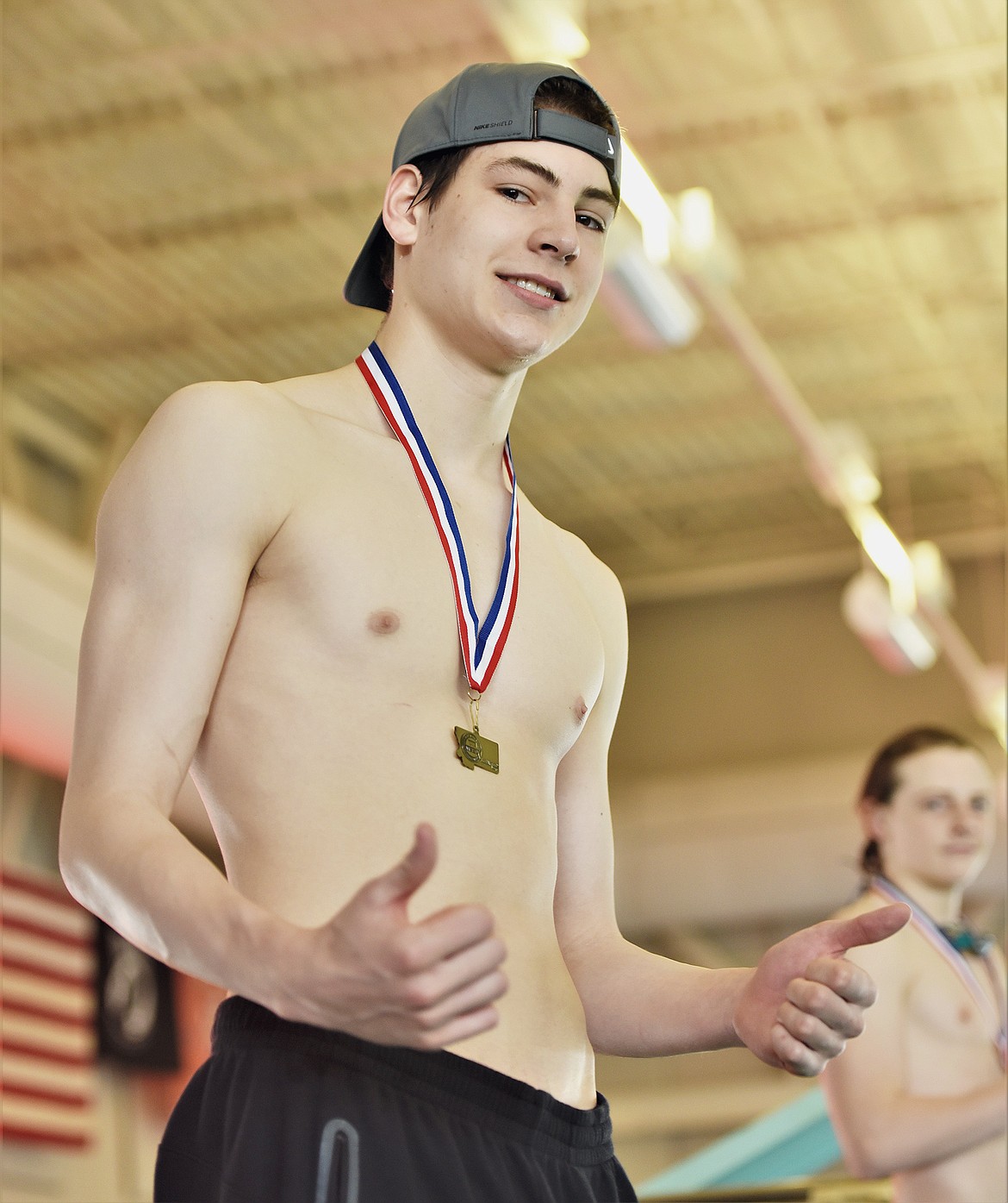 Whitefish's Logan Botner recieves a medal for a first-place finish in the 500 yard freestyle race at the Montana Class A State swim meet on Saturday, March 6 in Polson. (Scot Heisel/Lake County Leader)
