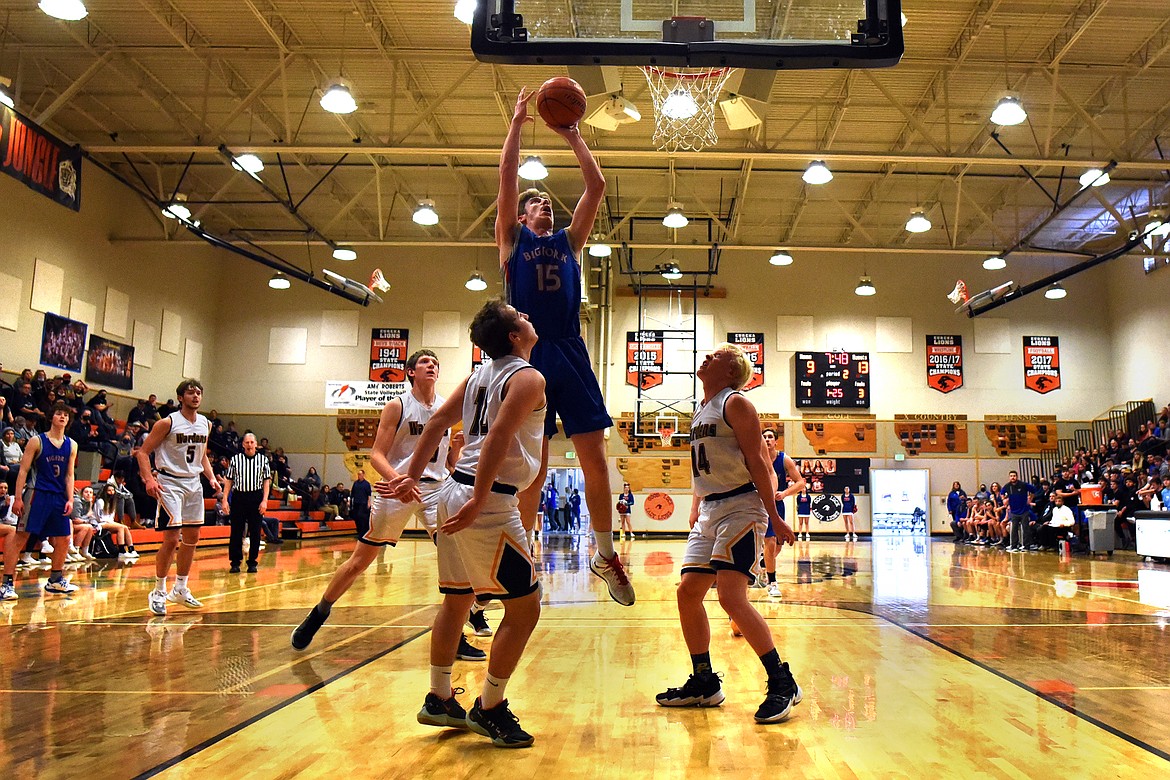 Bigfork's Bryce Gilliard rises above the Deer Lodge defense for two points in the semifinals of the Western B Divisional Basketball Tournament in Eureka Friday. (Jeremy Weber/Daily Inter Lake)