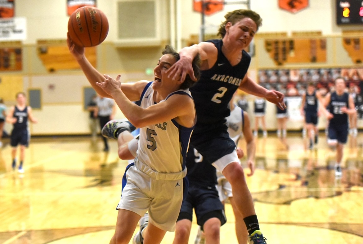 Bigfork's Walker Fisher is fouled by Anaconda's Jacob Greenwood while going to the basket in the Vikings' 45-35 win in the opening round of the Western B Divisional Basketball Tournament in Eureka Thursday. (Jeremy Weber/Daily Inter Lake)