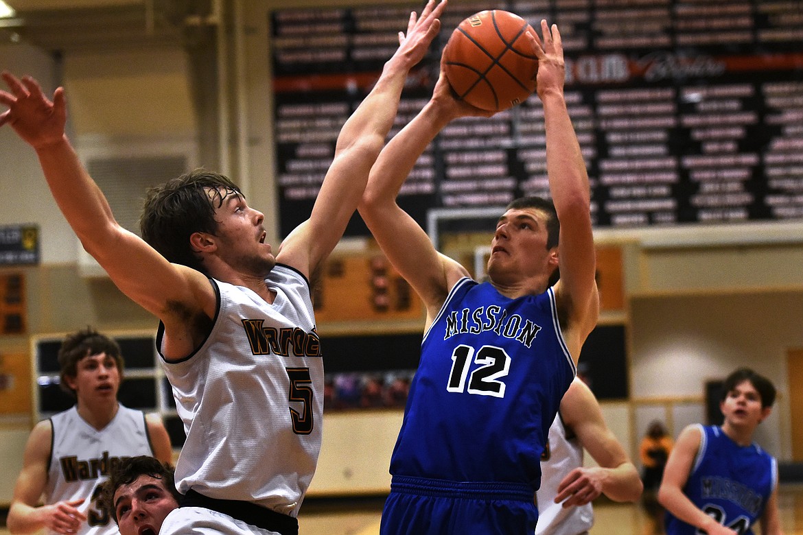 Mission's Ross McPherson pulls up for a jumper against Deer Lodge's Hunter Steinbach.