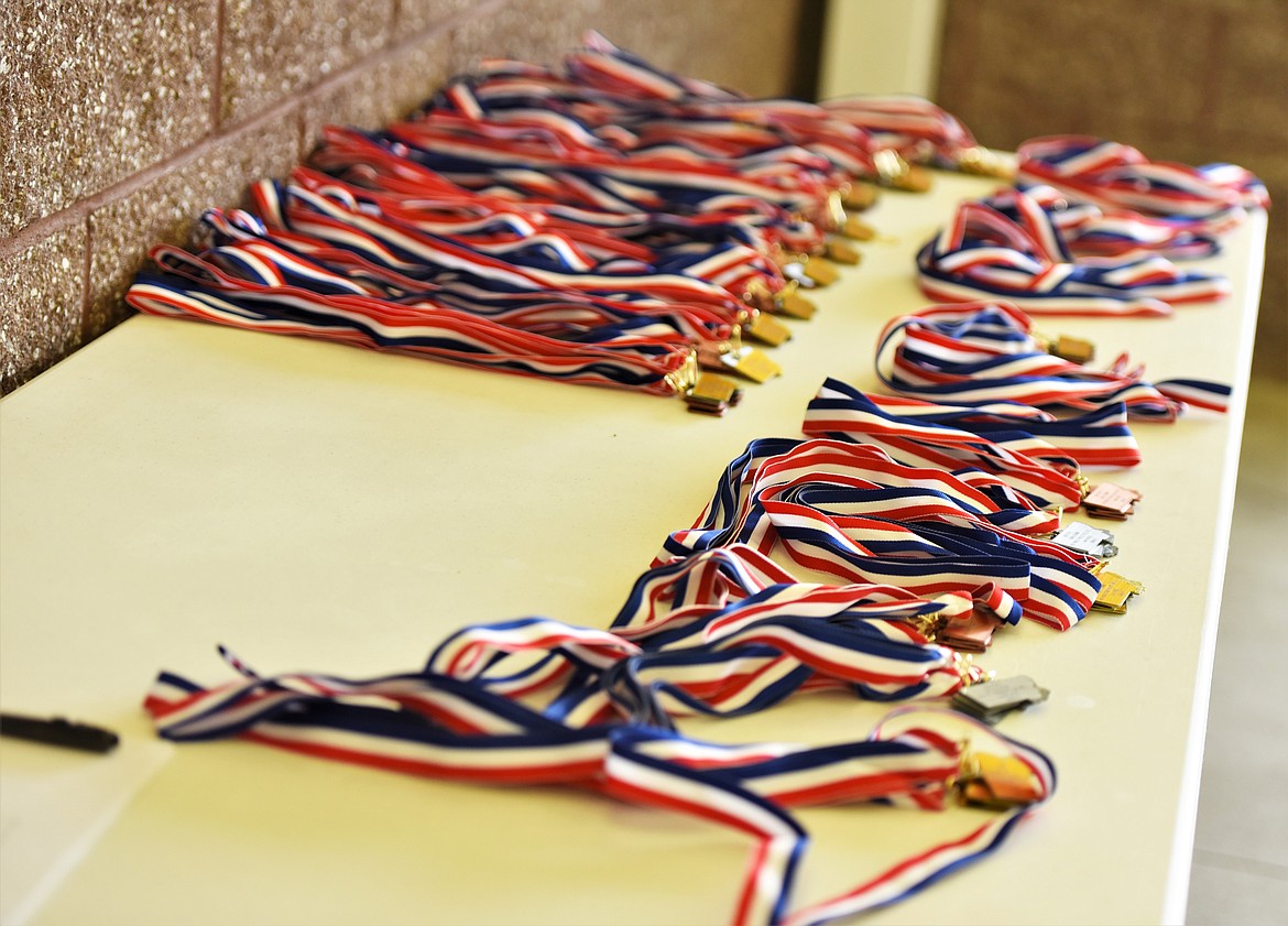 A table covered in medals for the Class A/B state swim meet at Polson. (Scot Heisel/Lake County Leader)