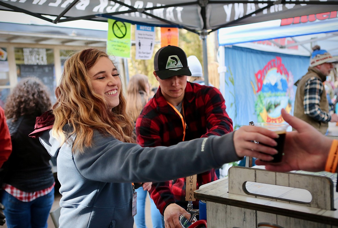 Mikayla Thomas, an employee at Lakeside's Tamarack Brewing Company, serves a beer to a guest during Bigfork Brewfest while Derek Barstow fills up another cup.
Mackenzie Reiss/Bigfork Eagle