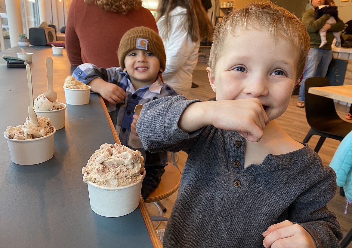 Lukas Kuhn, right, and Sonny Broggie enjoy heaping spoonfuls of Panhandle Cone & Coffee's housemade ice cream at the Coeur d'Alene locations free kids cup giveaway Tuesday afternoon. All tips donated by customers will go toward Kootenai County families connected with the Idaho Youth Ranch's adoption services. (MADISON HARDY/Press)