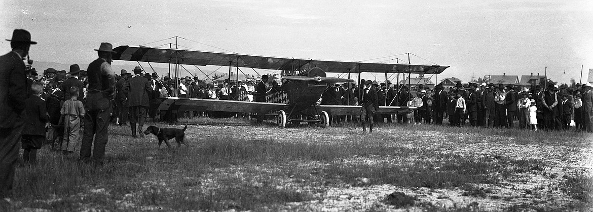 Curious Kalispell residents gather around a visiting barnstormer and his plane in 1920. (Vernon Weed photo)