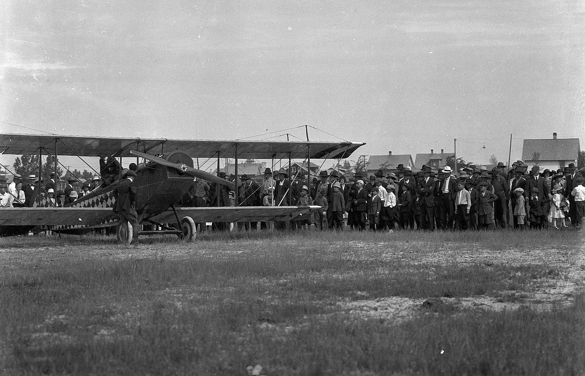 Curious Kalispell residents gather around a visiting barnstormer and his plane in 1920. (Vernon Weed photo)