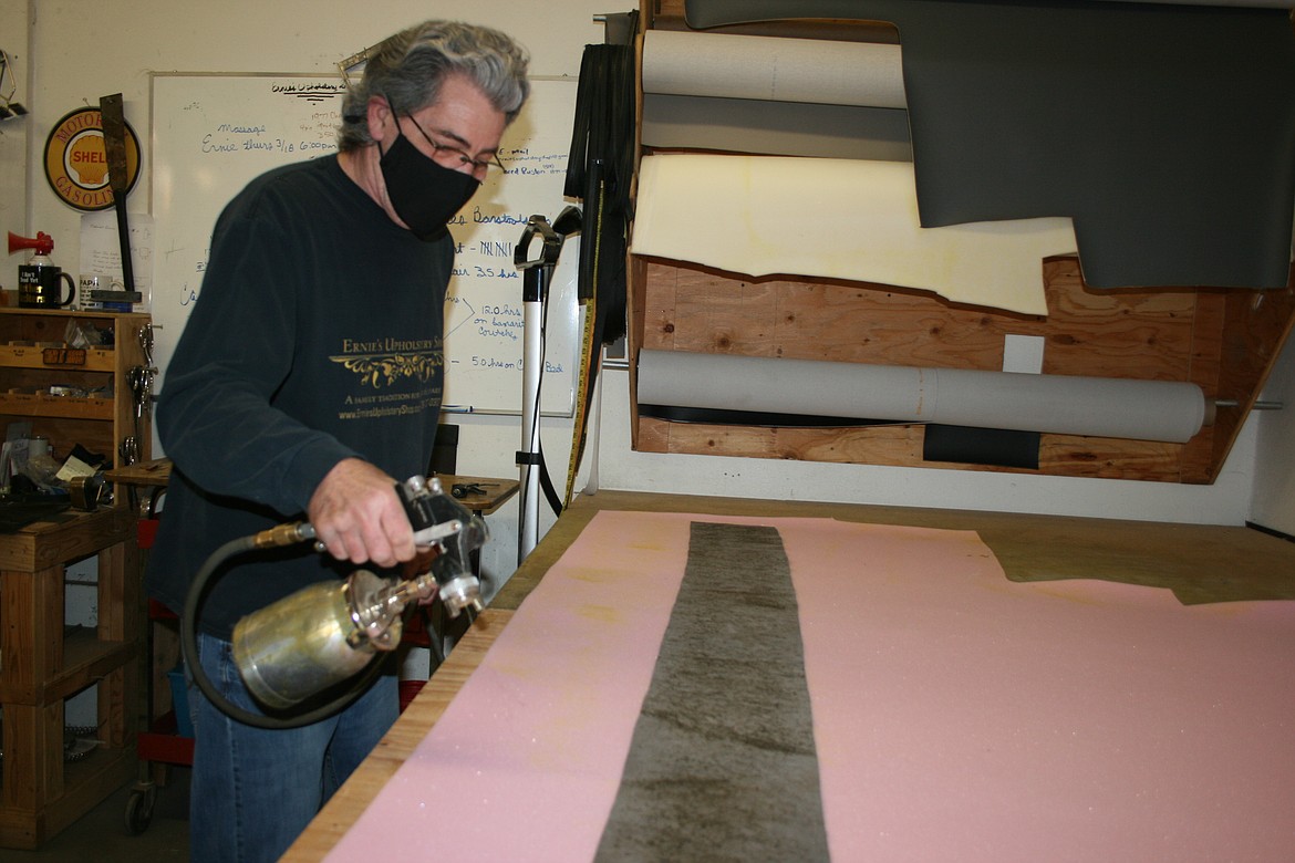 Part of upholstering a chair is extra support for the outer fabric. Ernie Derricott, owner of Ernie's Upholstery, adds glue to backing foam.