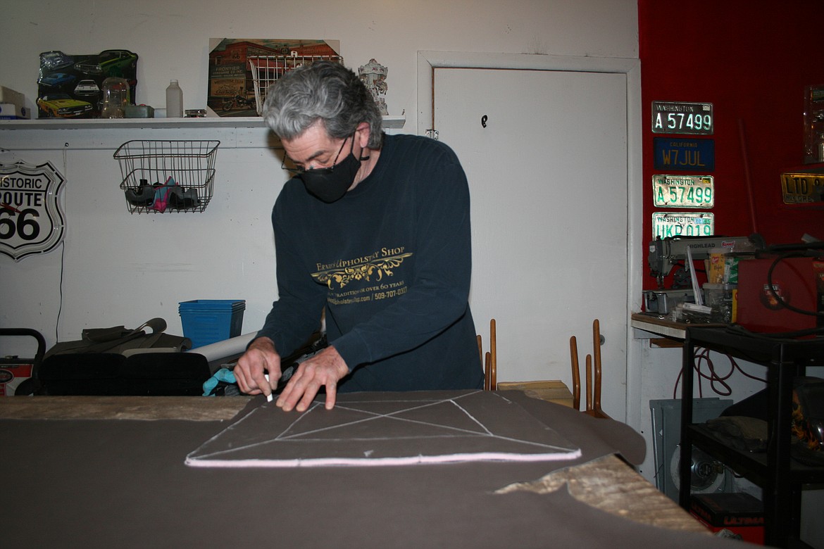 Ernie's Upholstery owner Ernie Derricott traces out the pattern for a dining chair seat.