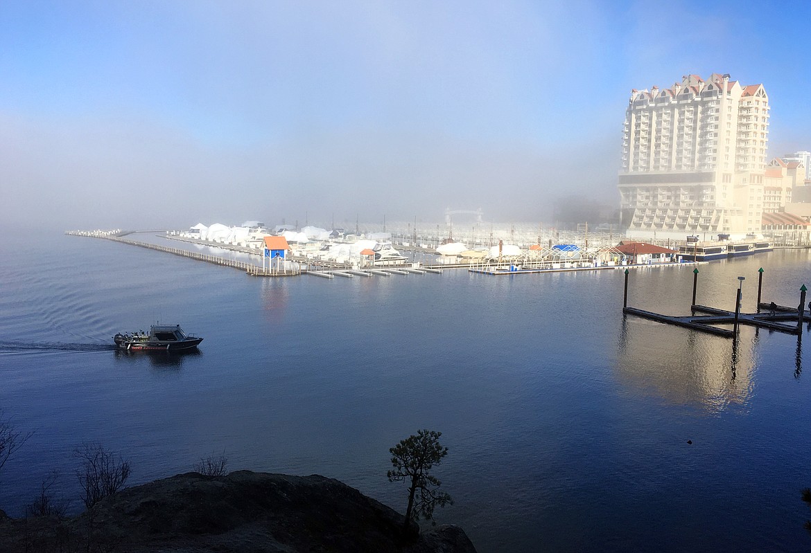 A boat cruises toward The Coeur d'Alene Resort marina while a mist settles over the area Thursday morning.