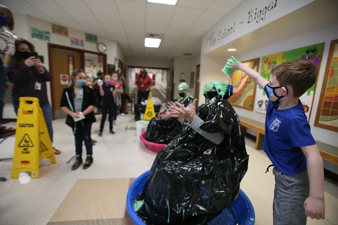 Ramsey Magnet School of Science second-grader Beck Engebretsen pours green slime on P.E. teacher Trena Burt's head on Friday.