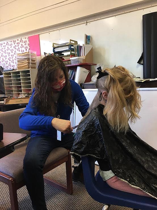 Cori Miranda, former beautician and current Alberton kindergarten teacher, works on a hair style for student Olivia McGaughy during the “Spring Spruce Up.” (Monte Turner/Mineral Independent)