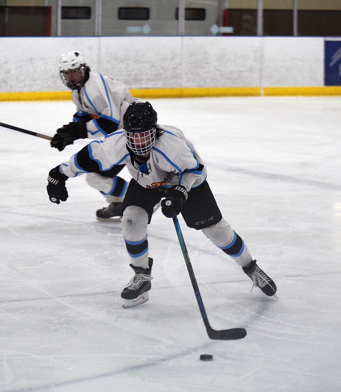 Finn Davidson along with George Herne look to advance the puck into the offensive zone in a game at Stumptown Ice Den earlier this season. (Whitney England/Whitefish Pilot)