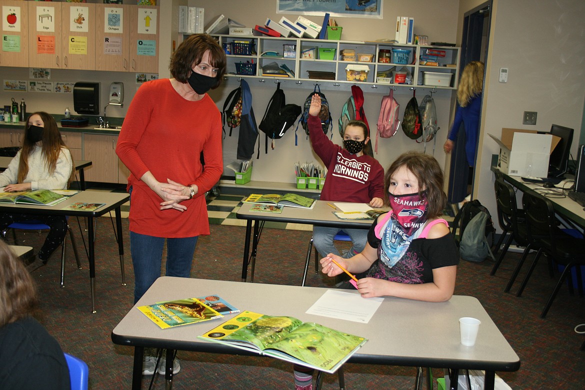 Soap Lake third grade teacher Sherry Fair (left) discusses a lesson with her student Cynful Meria. The experience of operating schools during the COVID-19 pandemic has been different for different districts.