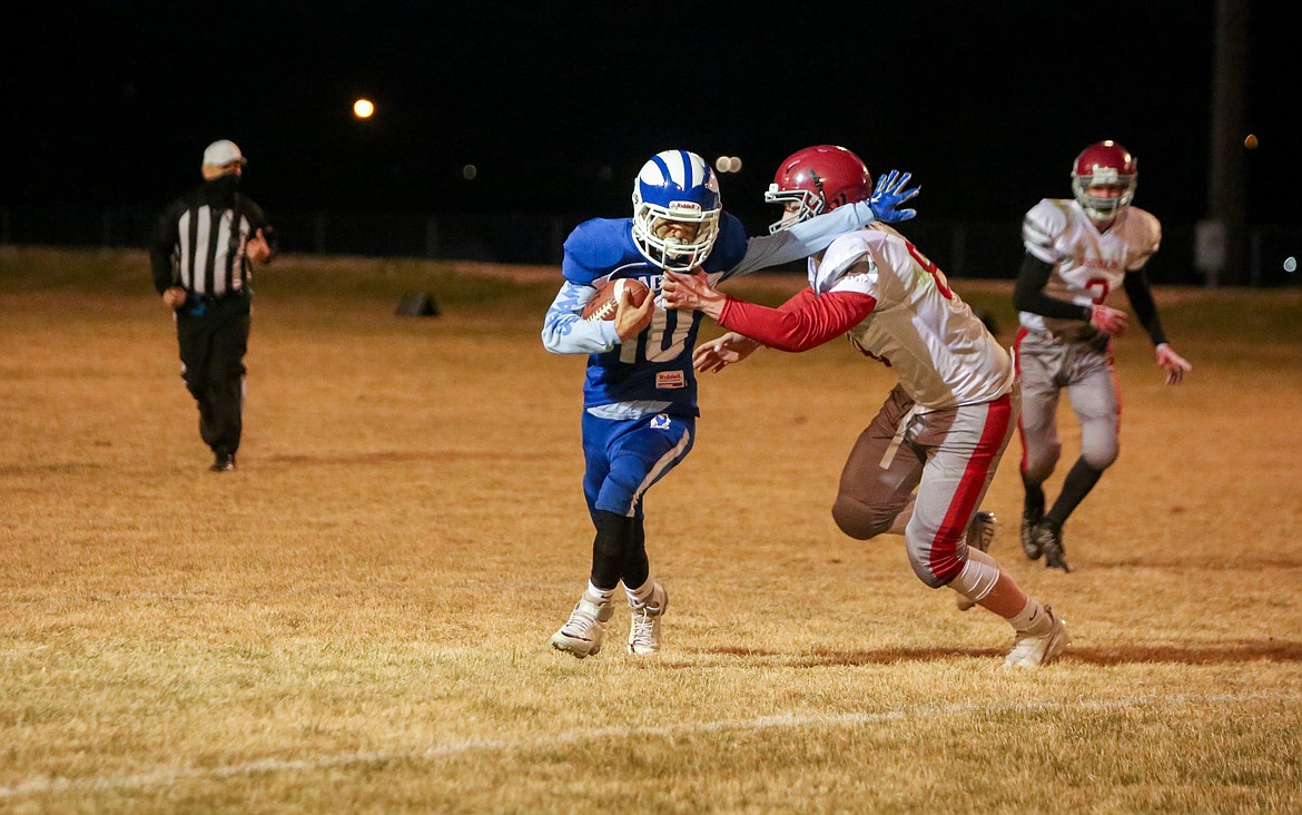 Soap Lake freshman Alex Bustos holds off the defender as he makes his way down the field on Thursday night at Soap Lake High School.