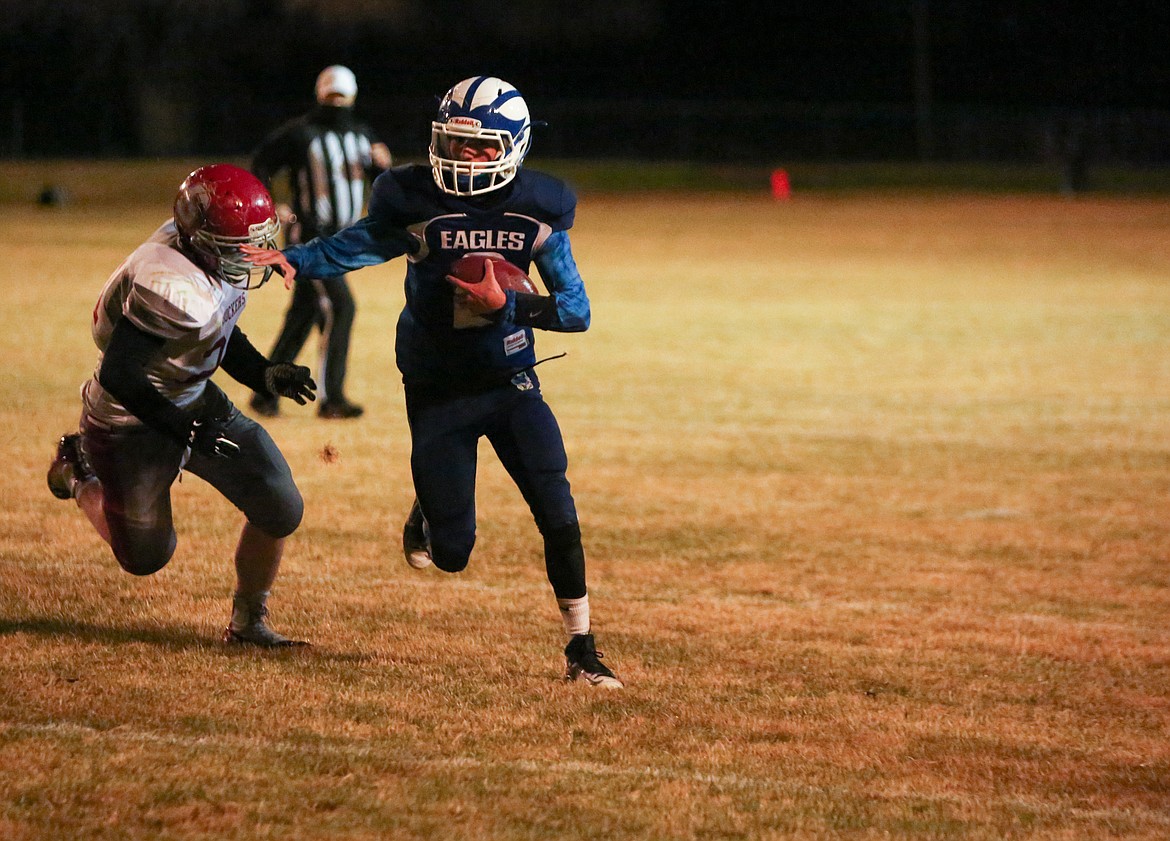 Soap Lake quarterback Diego Garza holds off the defender as he rushes downfield in the second half against Waterville on Thursday at Soap Lake High School.