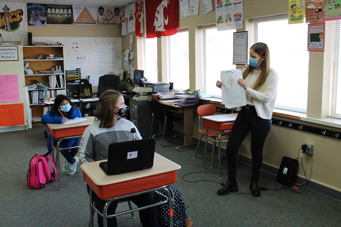 Ms. Mofford shows examples of posters of patriots and loyalists to her fifth grade class on Wednesday, March 17.