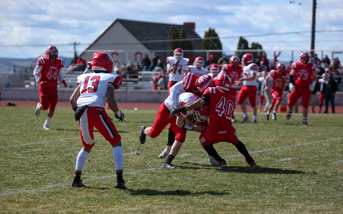 Othello's Ethan Medina combines with his teammate for the tackle on the Clarkston ball carrier on Saturday afternoon at Othello High School.