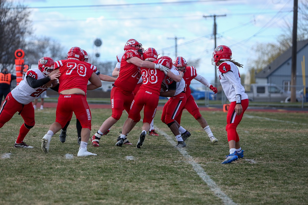 A trio of Othello defenders combine to take down the Clarkston running back behind the line on Saturday afternoon at Huskie Stadium in Othello.