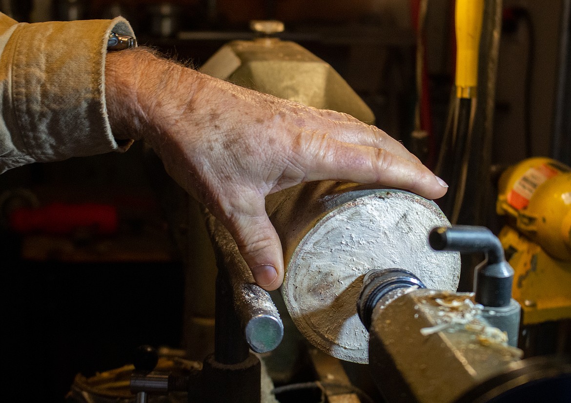 Merle Hardy's hand rests on a piece of wood secured in his wood lathe in his garage in Moses Lake on Monday afternoon.