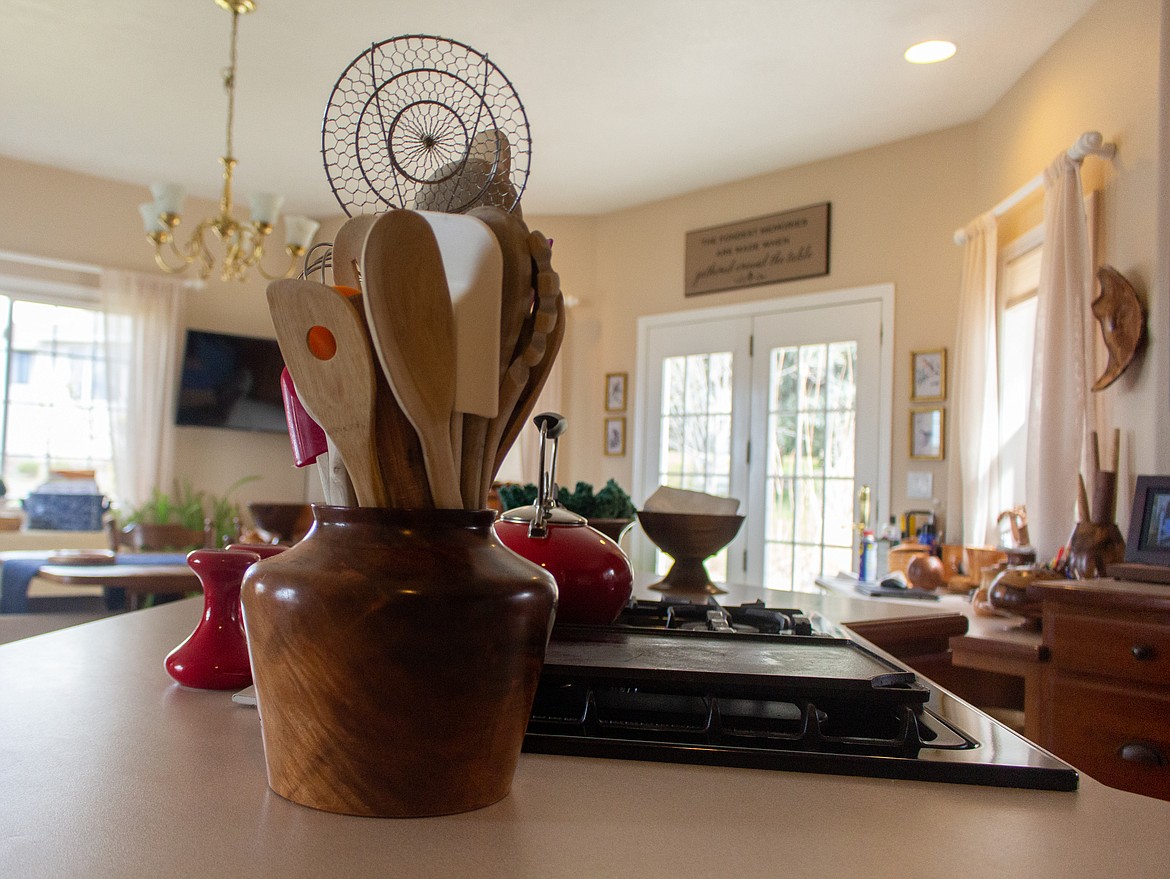Kitchen utensils fill a wooden container crafted by Merle Hardy, one of many of his works around his home in Moses Lake.