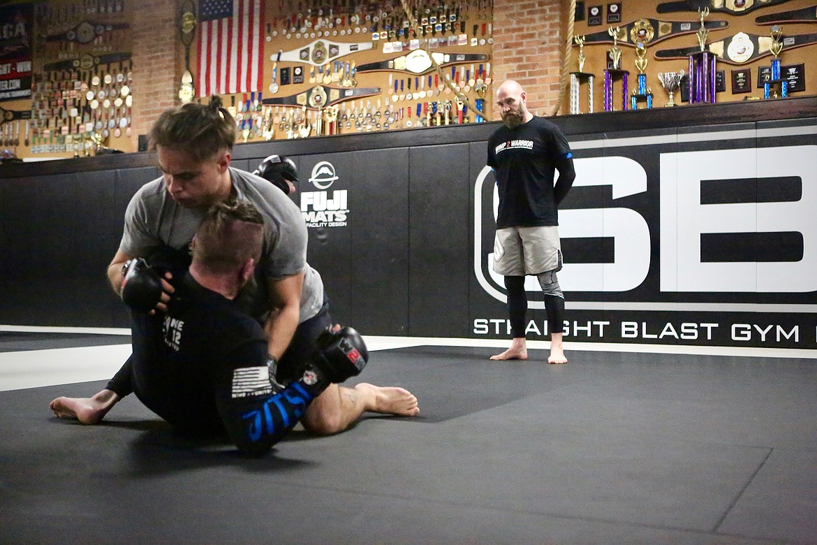 Cody Bessette looks on while Wimp 2 Warrior participants grapple at SBG Kalispell on Monday morning.
Mackenzie Reiss/Bigfork Eagle