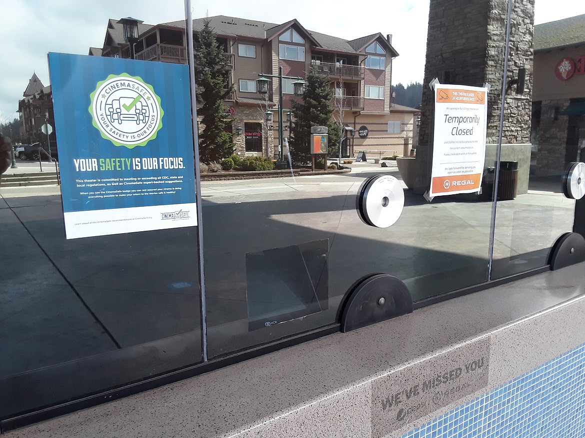 Only a few informative signs and the reflection of neighboring businesses can be seen along the glass of the Regal Riverstone box office. The popular theater initially closed because of the pandemic in March of 2020, opening briefly in late August before shuttering again. (CRAIG NORTHRUP/Press)