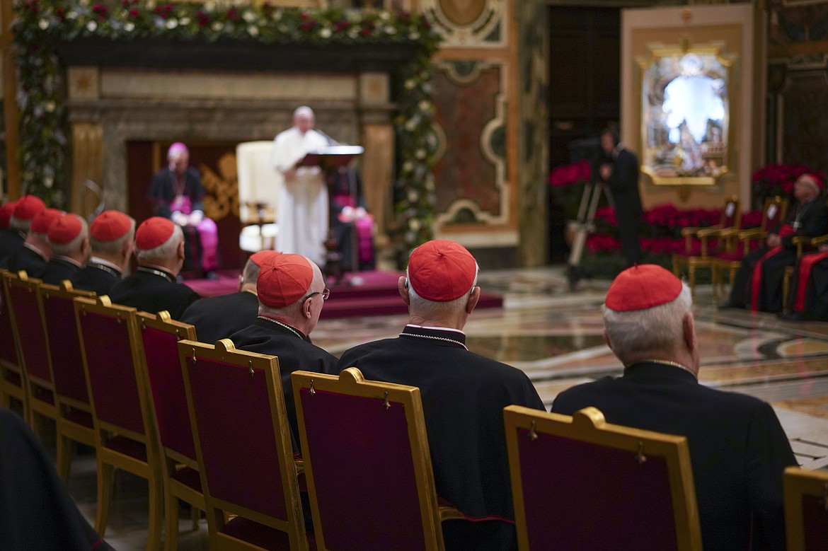 Cardinals listen as Pope Francis, background, delivers his Christmas greetings to the Roman Curia, in the Clementine Hall at the Vatican, Saturday, Dec. 21, 2019. Pope Francis has ordered pay cuts for Holy See employees, including slashing cardinals’ salaries by 10%. Francis in a letter made public by the Vatican on Wednesday, March 24, 2021, noted that the pandemic emergency “negatively impacted all sources of revenue” for the Holy See and Vatican City State.