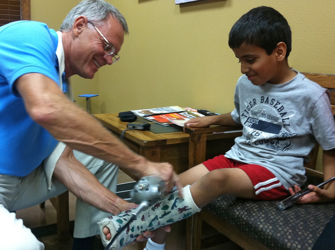 Certified prosthetist and orthotist Bob Miller works with a little boy, Hassib from Afghanistan, in this 2013 photo. Kootenai Prosthetics and Orthotics through the years has provided many scholarships for people overseas in need of prosthetic or orthotic equipment.
