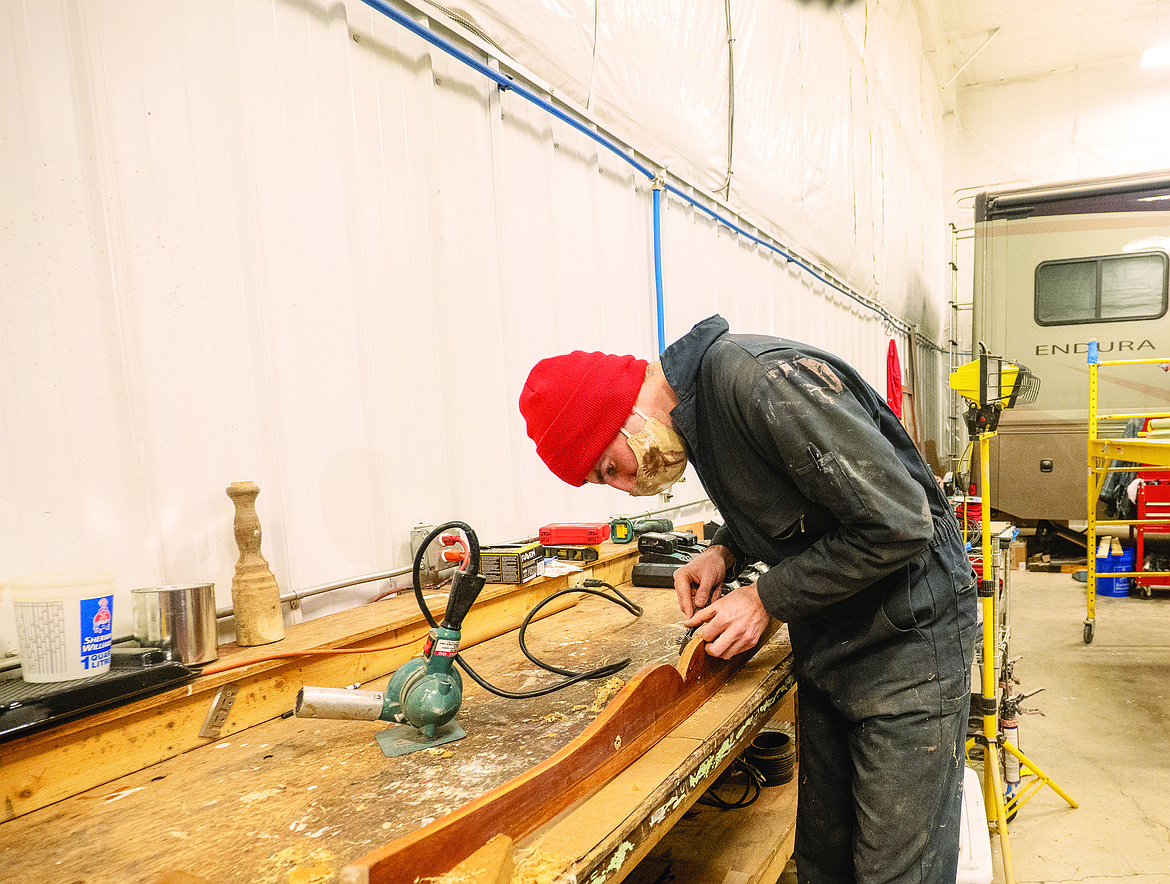 Sam Wagner works on the moustache trim for the historic 1926 boat recently at the Glacier Park Boat Company shop in Columbia Falls. (Chris Peterson/Hungry Horse News)