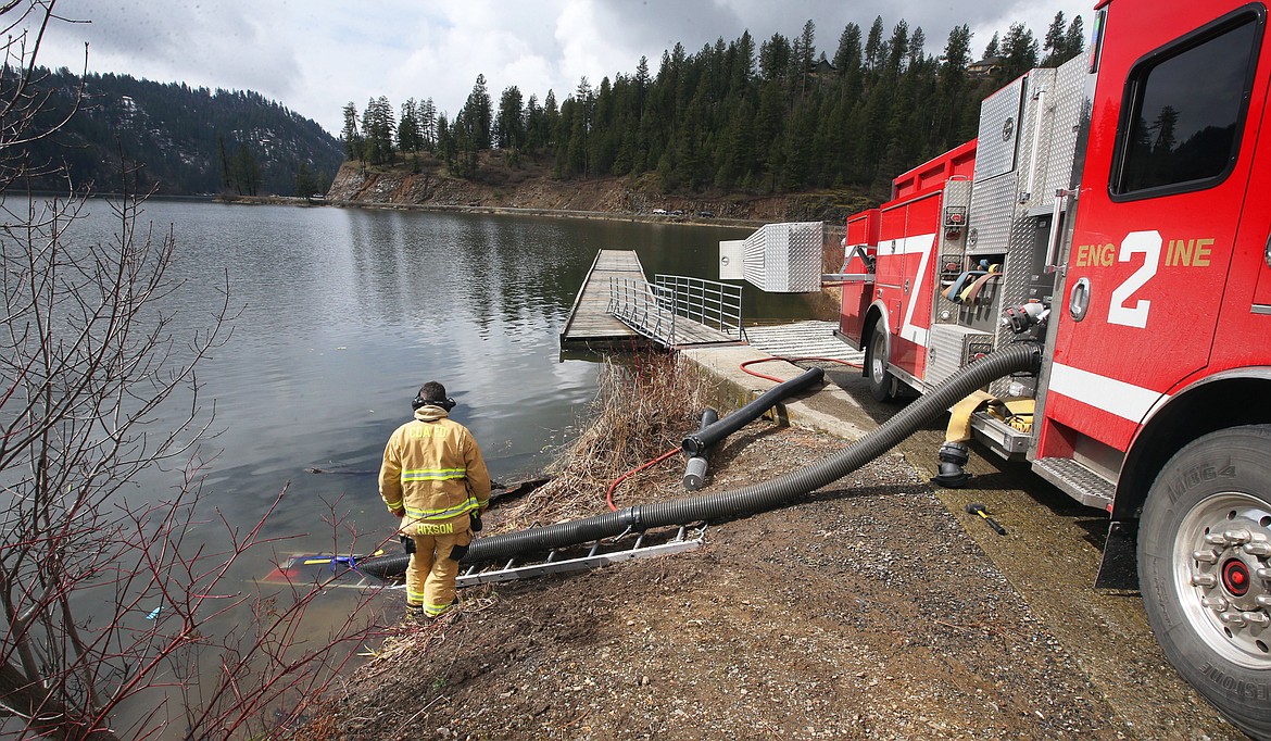 The Coeur d'Alene Fire Department uses one of its engines to fill water tenders at Fernan Lake Thursday to battle a house fire.