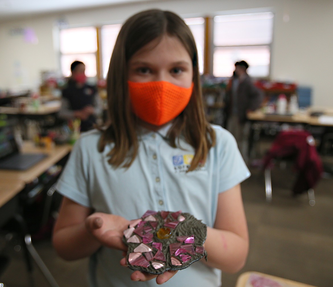 Sorensen third-grader Aria Young on Thursday shows off her mostly completed wild rose piece that will be added to a mural that will be installed on the outside of the school.