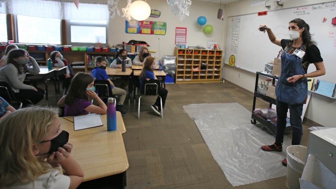 Spokane artist Melissa Cole gives Sorensen Magnet School students in Moira DuCoeur's third grade class a lesson in mosaic work on Thursday. Cole is the artist-in-residence leading school-wide work on a mural that will be installed this spring.