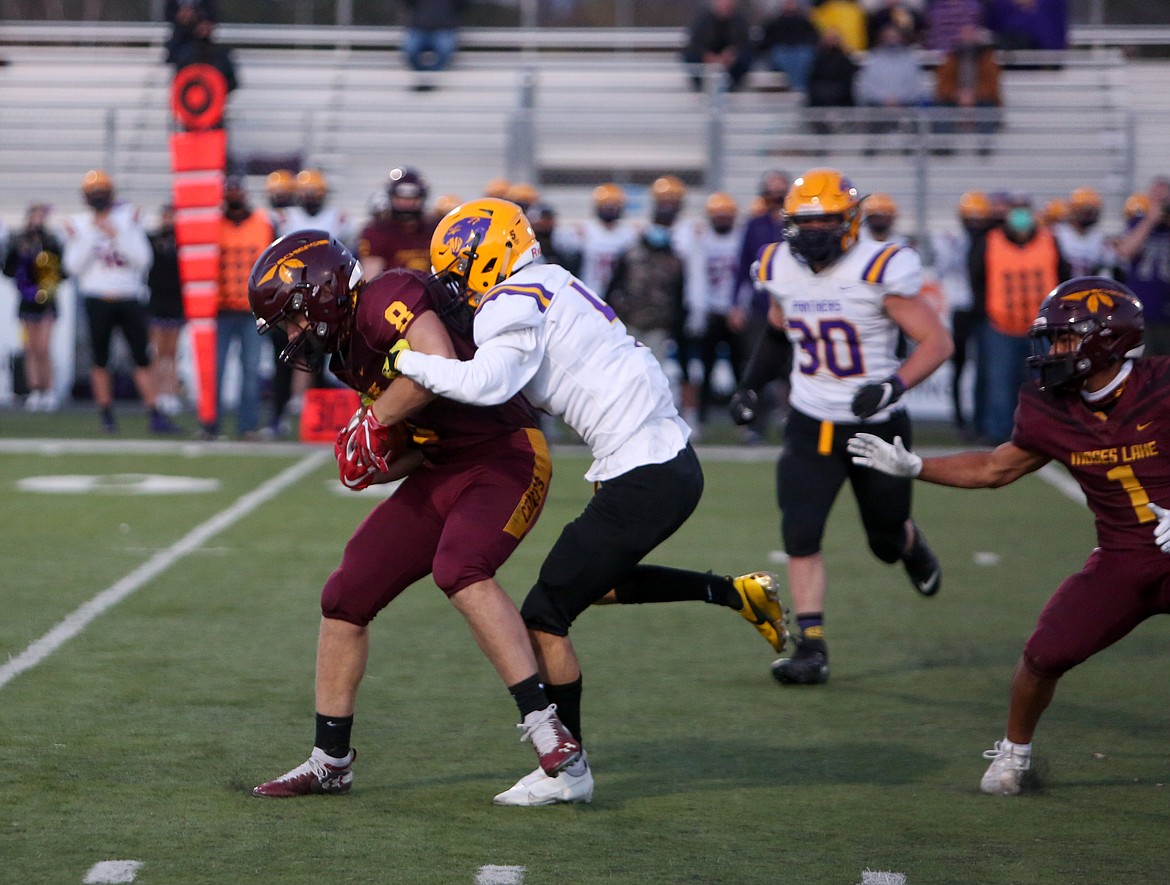 Moses Lake's Zach Reyer fights forward for more yards with a Wenatchee defender draped all over him in the first half on Friday night in Moses Lake.