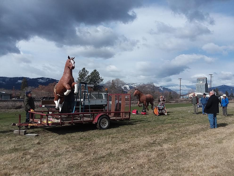 Chilaili Wachiwi plays one of her Native American flutes as the horse is unloaded and people watch during last Friday's dedication of Kenton Pies' third horse sculpture. The rest are the dedicated workers which worked with Pies to build the works of art. (Monte Turner/Valley Press)