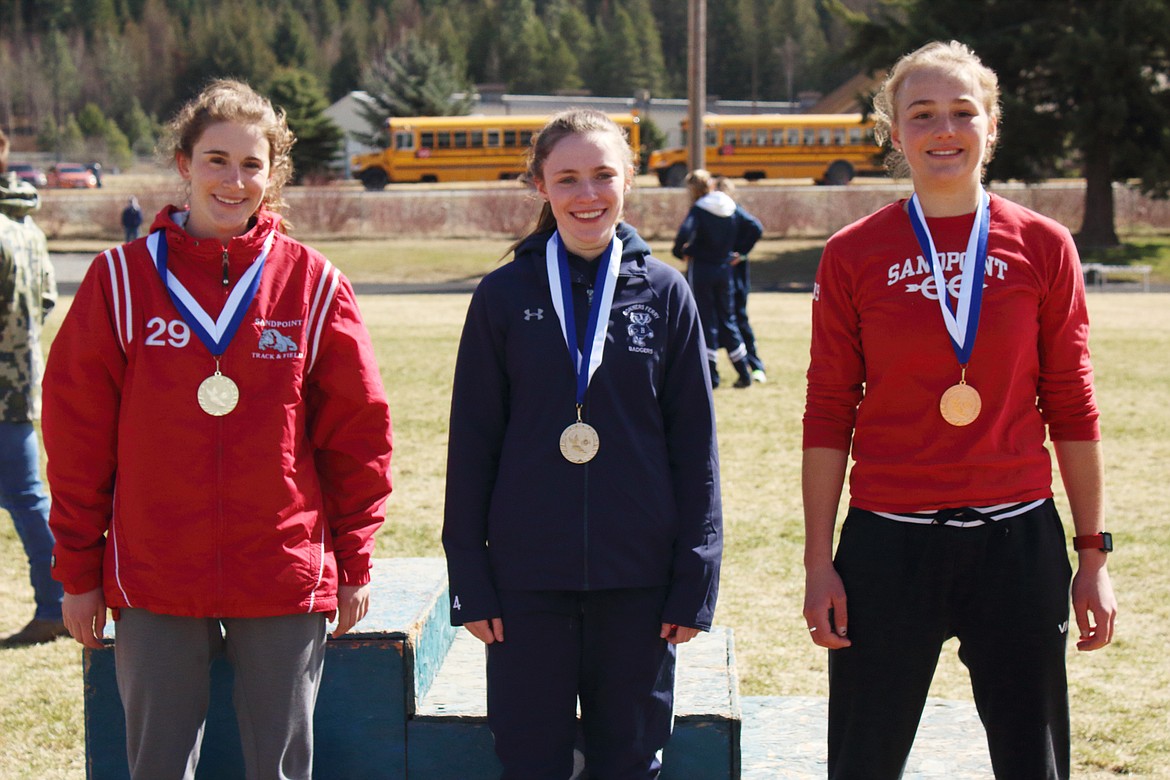 Junior Piper Frank (left) and sophomore Ara Clark (right) pose for a photo with the medals they earned in the girls pole vault.